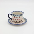 Hand-painted Bolesławiec cup and saucer decorated with a charming strawberry pattern. Traditional Polish pottery perfect for coffee, tea, and kitchen decor.