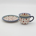 Hand-painted Bolesławiec cup and saucer decorated with a charming strawberry pattern. Traditional Polish pottery perfect for coffee, tea, and kitchen decor.